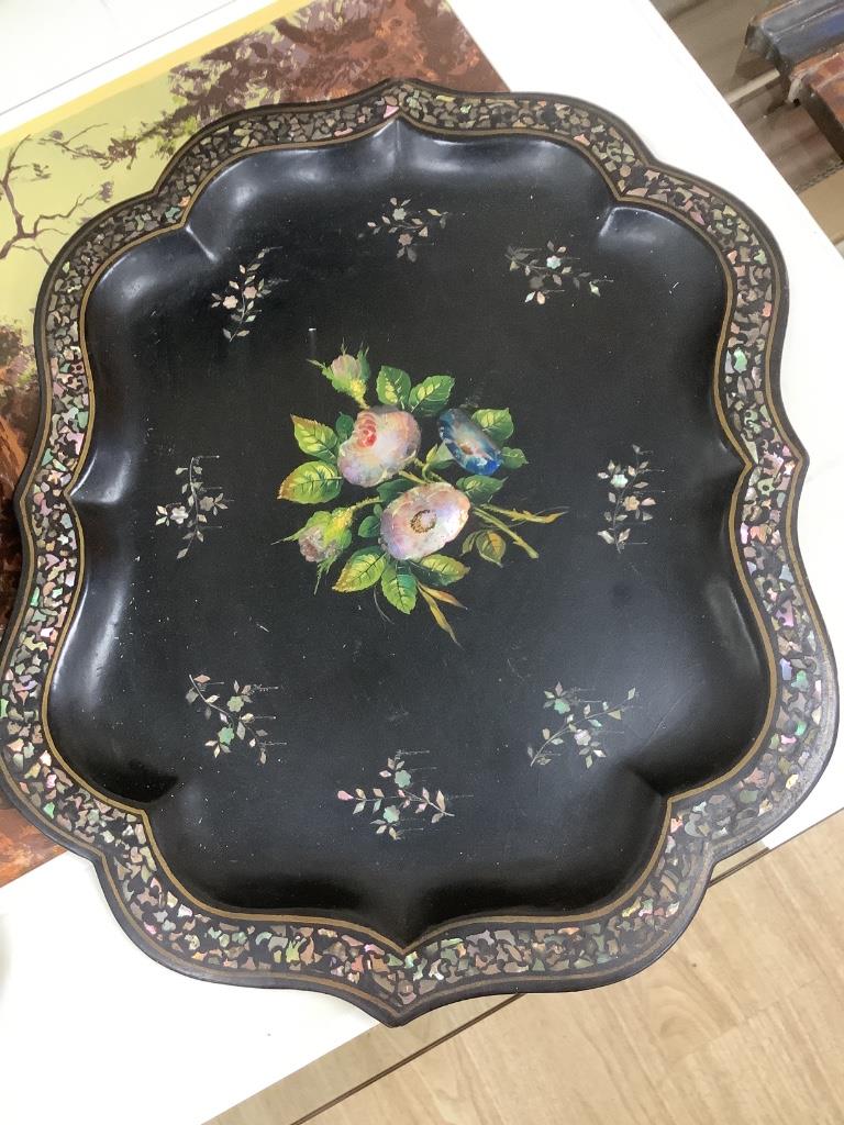 A Victorian papier mache shaped tray with painted floral panel with mother of pearl and a smaller similar tray, largest 78 x 59cm